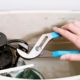 Plumber inspecting a running toilet and checking the tank components to identify the cause of continuous water flow | Why Does My Toilet Keep Running?