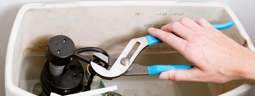 Plumber inspecting a running toilet and checking the tank components to identify the cause of continuous water flow | Why Does My Toilet Keep Running?